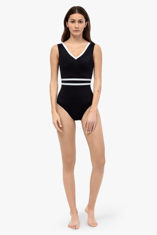 Woman wearing sustainable black one-piece swimsuit with white waistband | Lumiere Paris